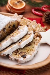 Photo of Traditional Christmas Stollen with icing sugar on wooden table, closeup