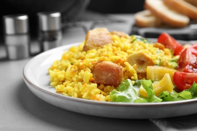 Photo of Delicious pilaf with chicken meat on light grey table, closeup
