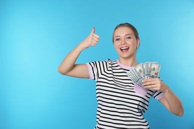 Photo of Portrait of happy young woman with money on color background. Space for text