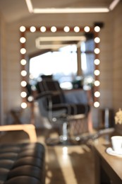 Photo of Blurred view of stylish barbershop interior with hairdresser workplace