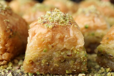 Photo of Delicious fresh baklava with chopped nuts on table, closeup. Eastern sweets