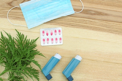 Photo of Flat lay composition with ragweed plant (Ambrosia genus) on wooden background. Seasonal allergy