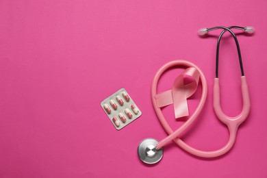 Photo of Breast cancer awareness. Pink ribbon, stethoscope and pills on color background, flat lay. Space for text