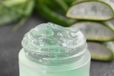 Photo of Jar of natural aloe gel against blurred background, closeup