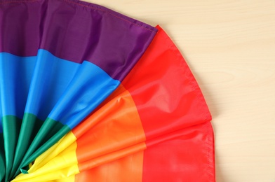 Photo of Rainbow gay flag on wooden background, top view. LGBT concept