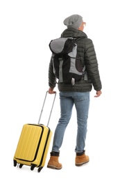 Photo of Man with suitcase and backpack walking on white background, back view. Winter travel