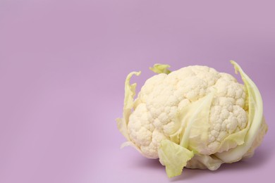 Photo of Fresh raw cauliflower on violet background. Space for text
