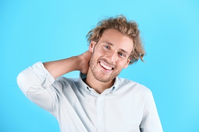 Photo of Handsome young man laughing on color background