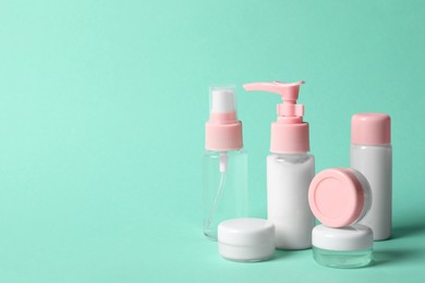 Photo of Cosmetic travel kit on turquoise background. Space for text