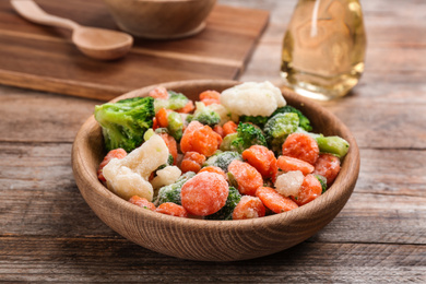 Photo of Tasty frozen vegetable mix on wooden table, closeup