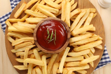 Photo of Delicious french fries served with ketchup on wooden table, top view