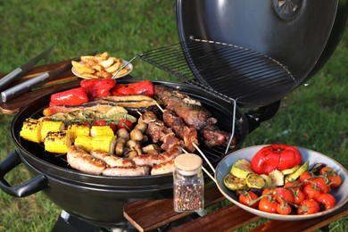 Photo of Tasty meat and vegetables on barbecue grill outdoors