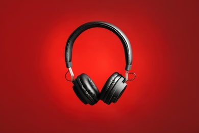 Photo of Stylish headphones with pads on color background
