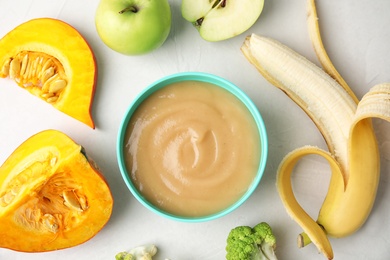 Flat lay composition with bowl of healthy baby food on gray background