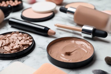 Photo of Composition with skin foundation, powder and beauty accessories on marble background