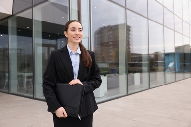Photo of Female real estate agent with leather portfolio outdoors