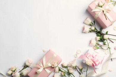 Photo of Flat lay composition with beautiful roses and gift boxes on white background. Space for text