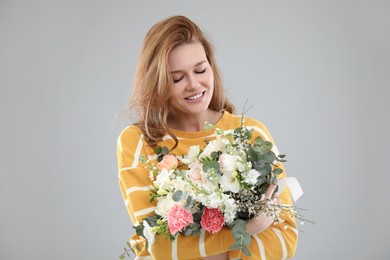 Photo of Beautiful woman with bouquet of flowers on grey background