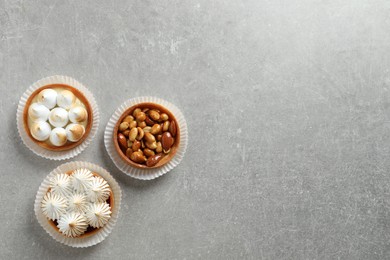 Photo of Different tartlets on light grey table, flat lay with space for text. Tasty dessert