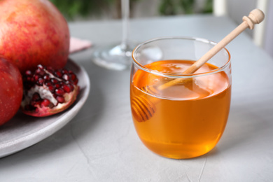 Photo of Jar with honey on grey table. Rosh Hashanah holiday
