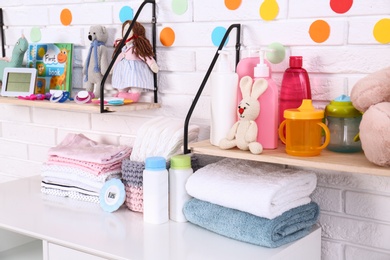 Photo of Baby accessories near white brick wall in nursery room