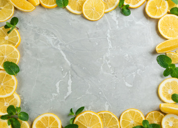 Photo of Frame made with ingredients for lemonade on grey marble background, top view. Space for text