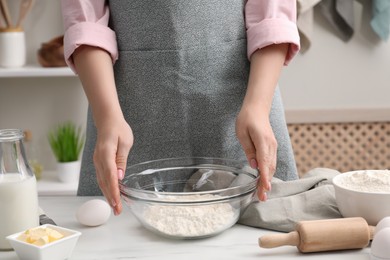 Photo of Making tasty baklava. Woman with ingredients for dough at white marble table, closeup