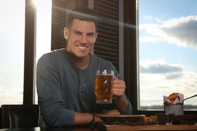 Man with glass of tasty beer in pub