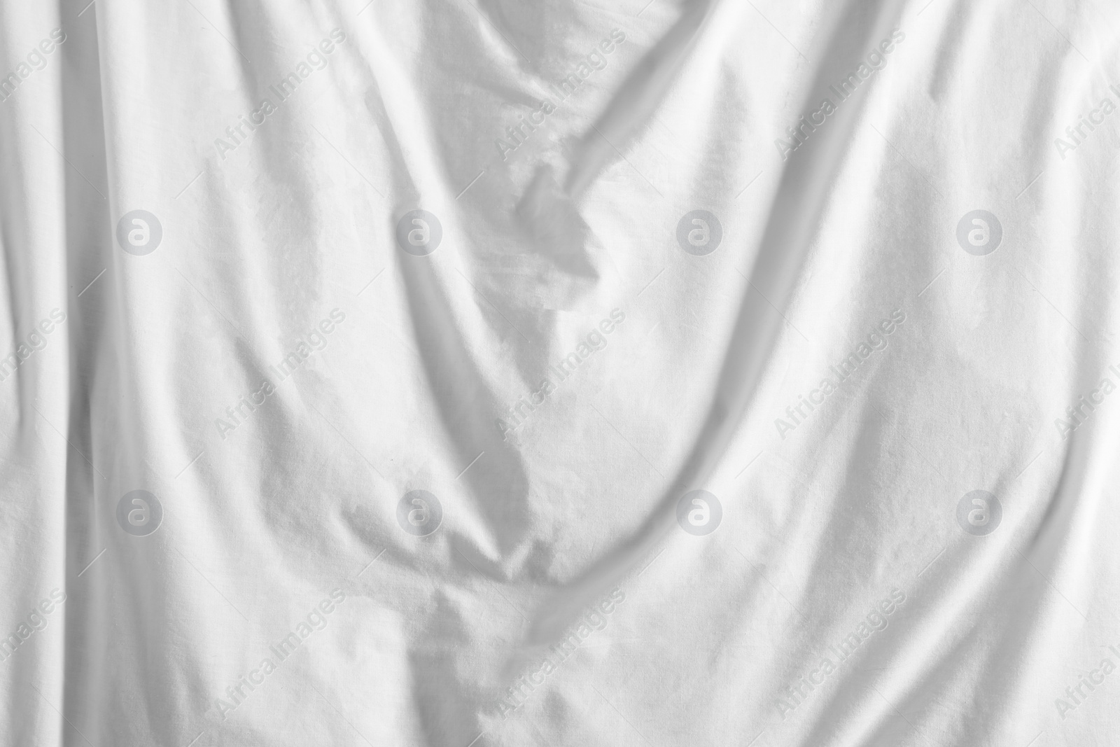 Photo of Crumpled white fabric as background, top view