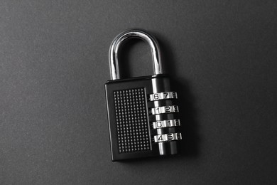 Photo of One steel combination padlock on black background, top view