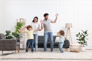 Photo of Happy family dancing and having fun in living room