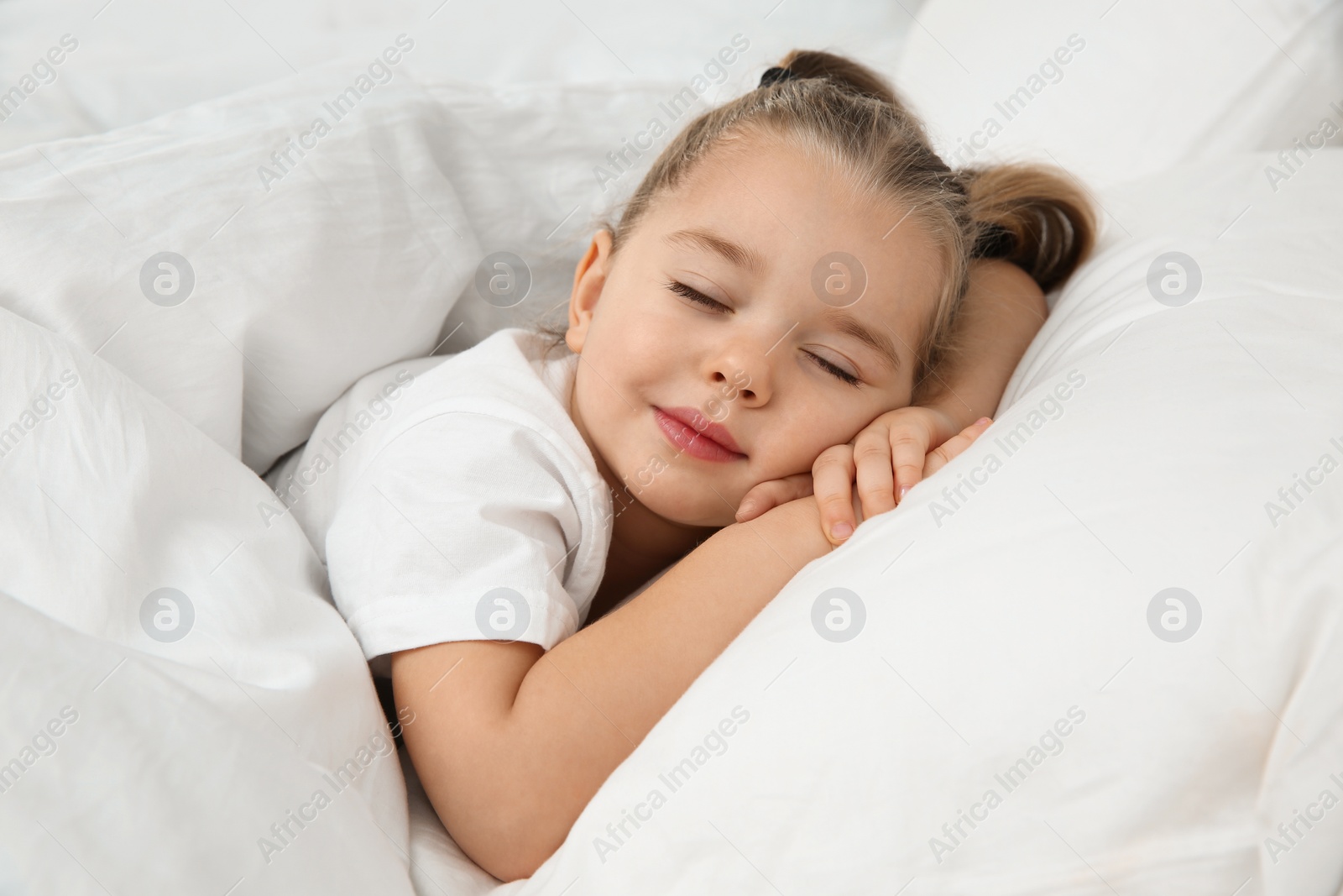 Photo of Beautiful little girl sleeping in bed. Bedtime schedule