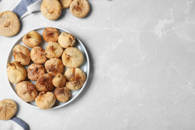 Tasty dried figs on light grey marble table, flat lay. Space for text