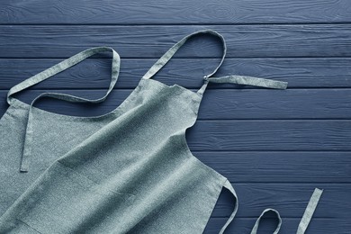 Photo of Color apron with pattern on grey wooden table, top view