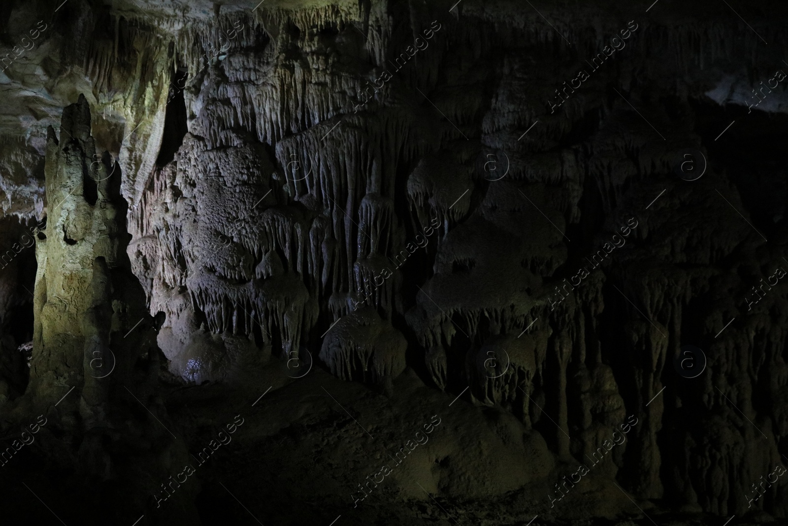 Photo of Picturesque view of many stalactite formations in dark cave