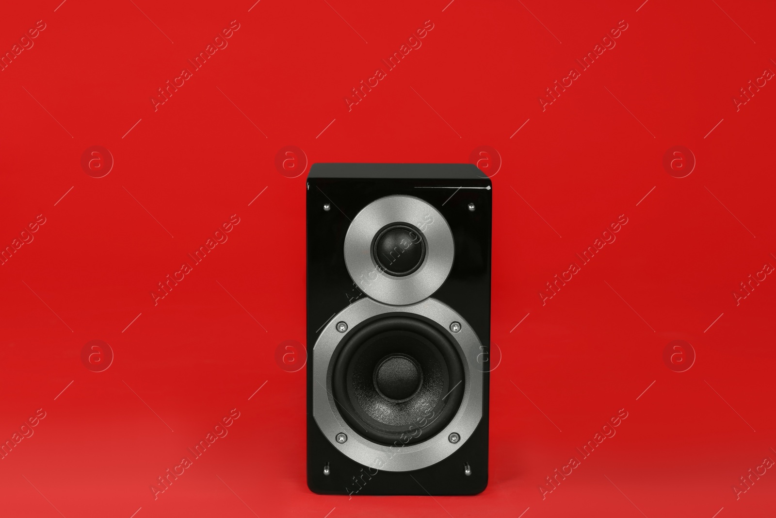 Photo of Modern powerful audio speaker on red background