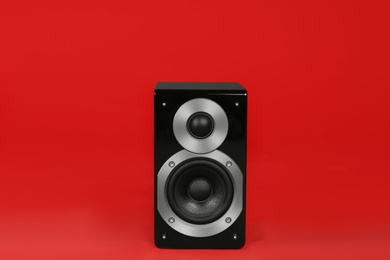 Photo of Modern powerful audio speaker on red background