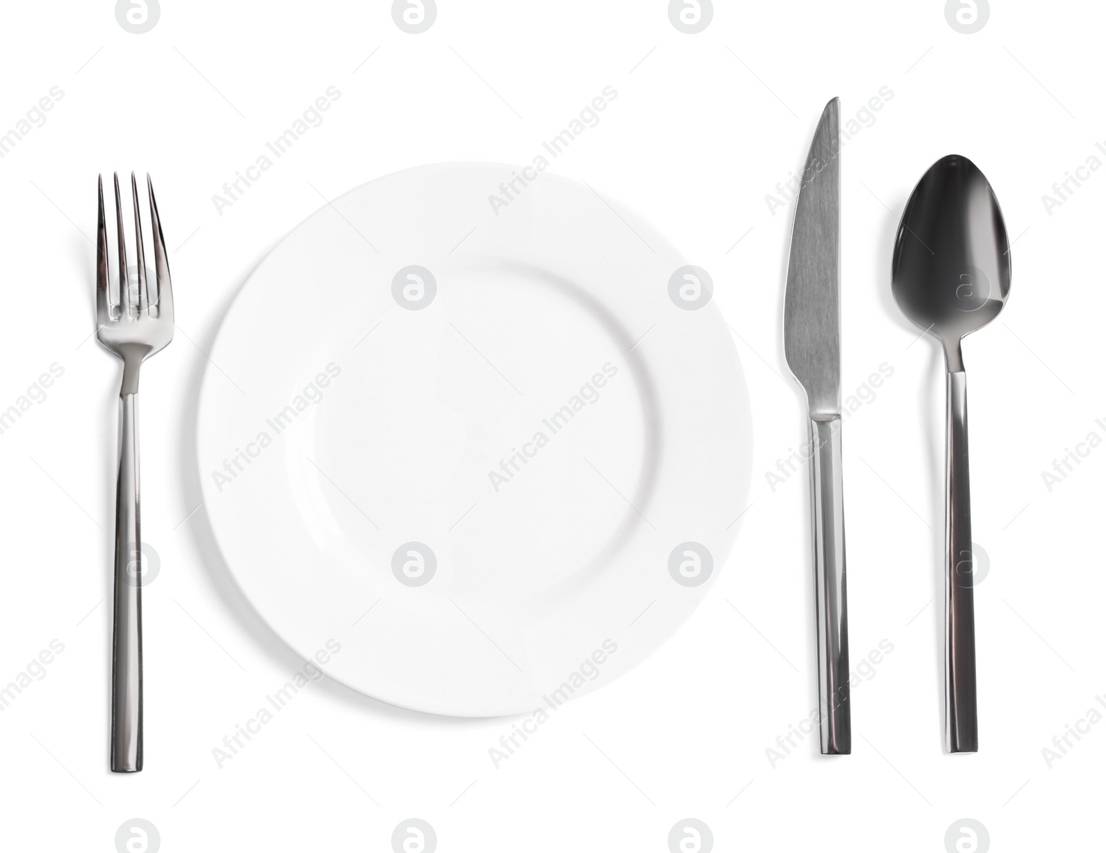 Photo of Clean plate and shiny cutlery on white background, top view