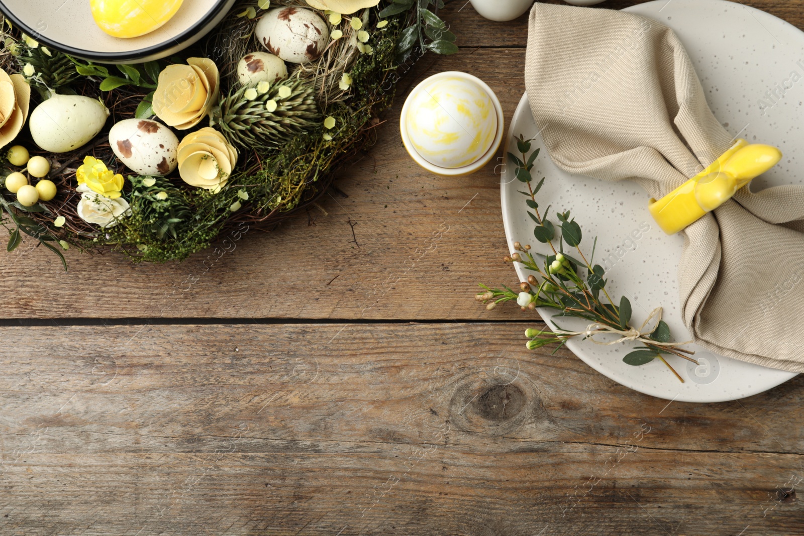 Photo of Rustic Easter table setting with eggs and floral decor, flat lay. Space for text