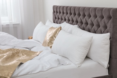 Photo of Soft pillows on comfortable bed in room. Modern interior design