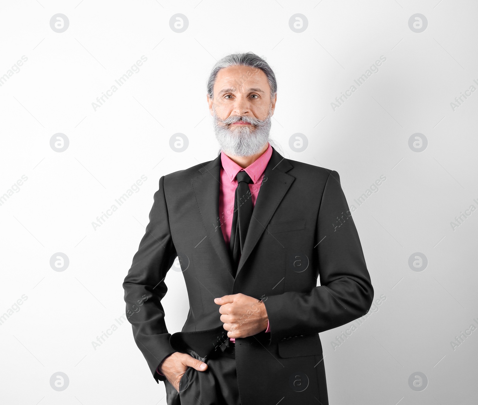 Photo of Handsome bearded mature man in suit on white background