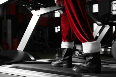 Authentic Santa Claus training on treadmill in modern gym, closeup