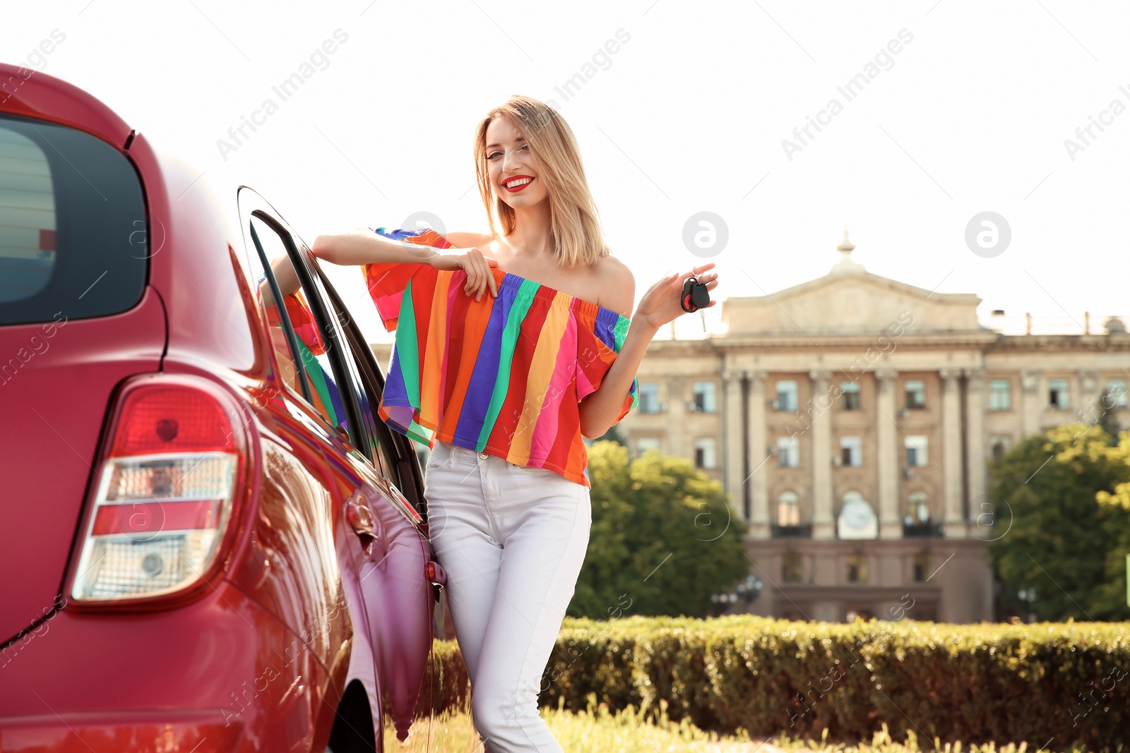 Photo of Young woman with car key near automobile outdoors