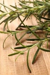 Sprigs of fresh rosemary on wooden table, closeup