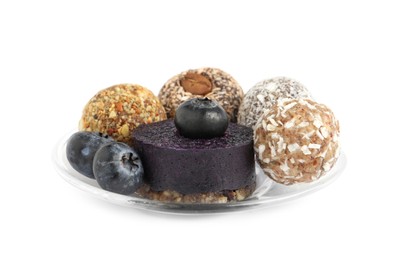 Photo of Different delicious vegan candy balls with fruit leather roll and blueberries on white background