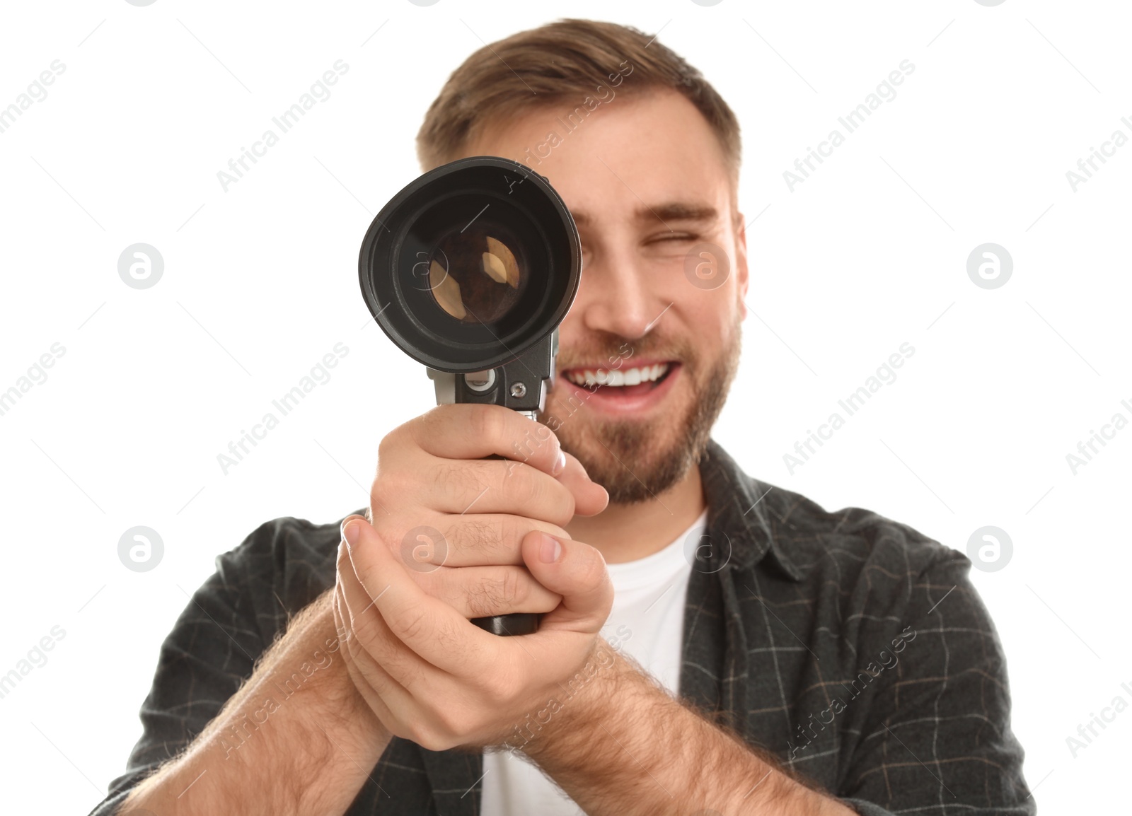 Photo of Young man with vintage video camera on white background, focus on lens