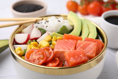 Photo of Delicious poke bowl with salmon, avocado and vegetables on white table, closeup