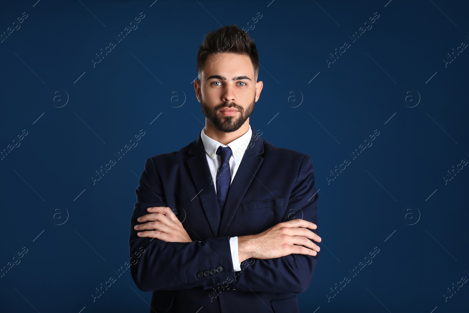 Photo of Portrait of handsome young man in office suit on color background