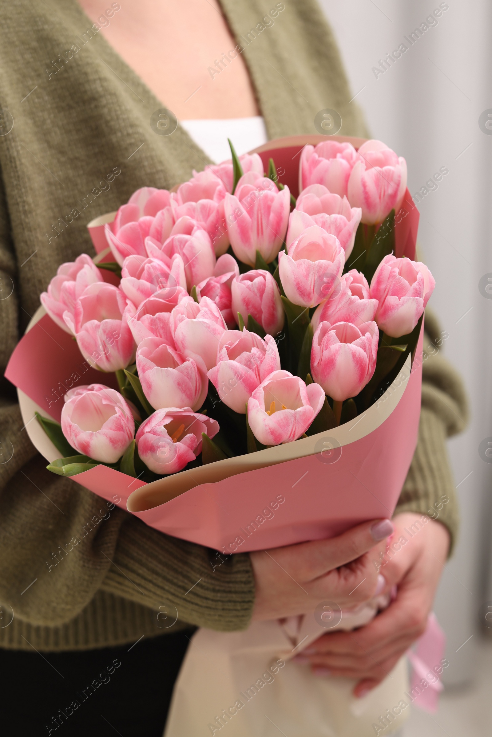 Photo of Woman with bouquet of beautiful fresh tulips on blurred background, closeup