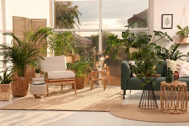 Photo of Stylish room interior with different houseplants and furniture near window